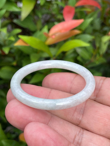 Handcrafted genuine Grade A Burmese jadeite infant bangle showcasing a translucent bright green and white appearance