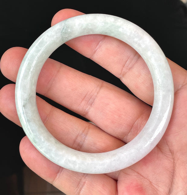 Close-up of a 56.5mm natural Grade A Burmese jadeite bangle featuring icy milky white and apple green hues, item JB378
