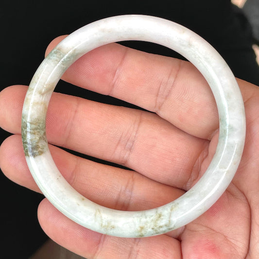 Close-up of a 58.5mm natural Grade A Burmese jadeite bangle featuring icy milky white and apple green hues, item JB435
