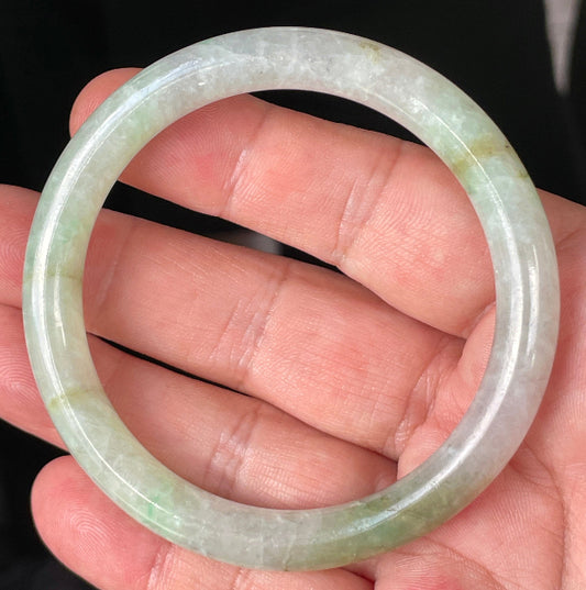 Close-up of a 58.4mm natural Grade A Burmese jadeite bangle featuring icy white, apple green, and imperial green hues, item JB245
