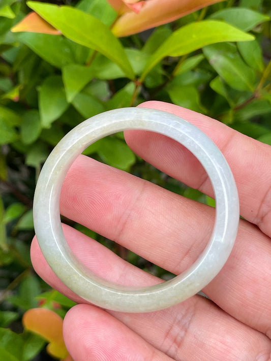 Close-up of a 40.5mm infant natural Grade A Burmese jadeite bangle featuring icy milky white, greyish, and moss green hues, item JB888