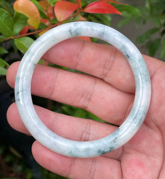 Close-up of a 58.7mm natural Grade A Burmese jadeite bangle featuring icy milky white, imperial green, and bluish hues, item JB957