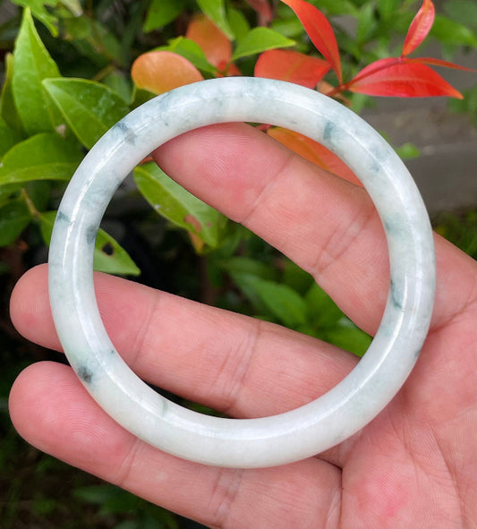 Close-up of a 58.5mm natural Grade A Burmese jadeite bangle featuring milky white and imperial green hues, item JB952
