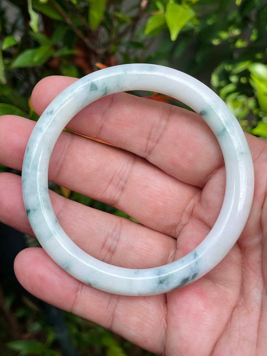 Close-up of a 58.8mm natural Grade A Burmese jadeite bangle featuring milky white and imperial green hues, item JB951