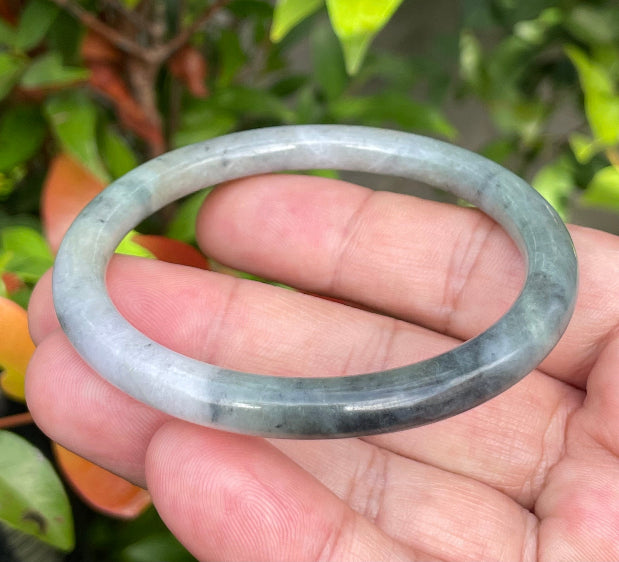 Handcrafted genuine Grade A Burmese jadeite bracelet showcasing a beautiful rare moss green, black, and white appearance