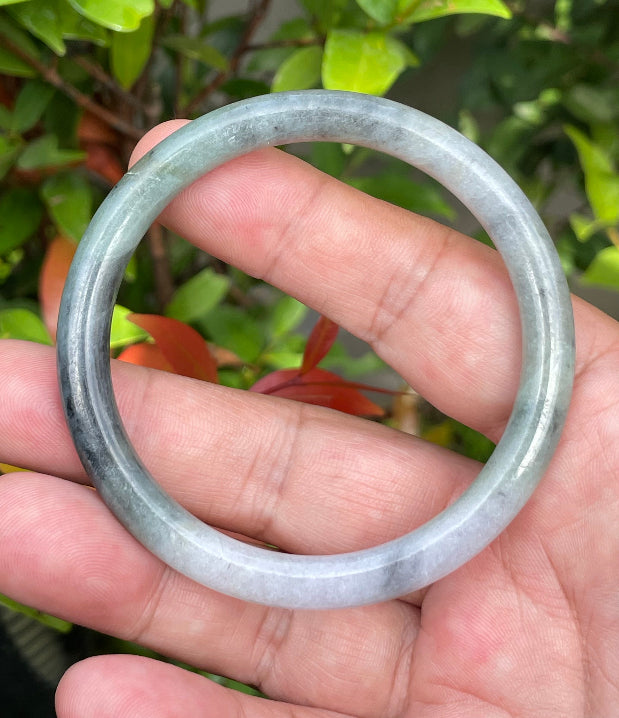 Handcrafted genuine Grade A Burmese jadeite bracelet showcasing a beautiful rare moss green, black, and white appearance
