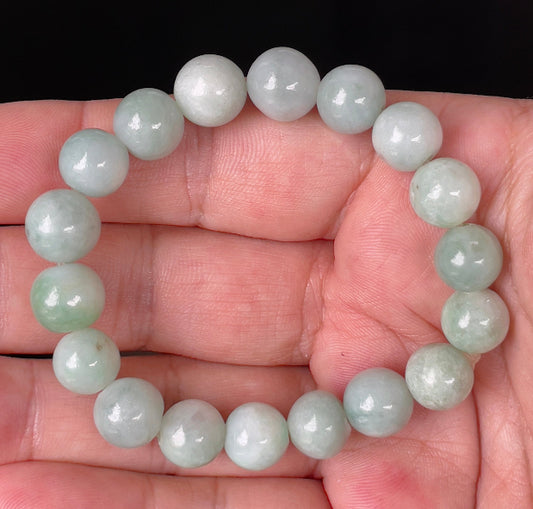 Close-up of a 10.5mm natural Grade A Burmese jadeite beaded bracelet featuring hand-shaped bluish apple green beads, item JBB136