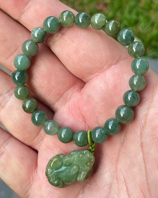 Close-up of a 7mm natural Grade A Burmese jadeite beaded bracelet featuring deep apple green beads and a Pixiu pendant, item JBB178