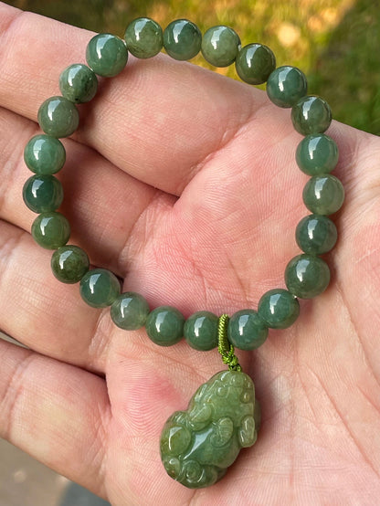 Handcrafted genuine Grade A Burmese jadeite stretch bracelet showcasing beautiful deep apple green beads with a hand-carved Pixiu pendant