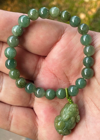 Handcrafted genuine Grade A Burmese jadeite stretch bracelet showcasing beautiful deep apple green beads with a hand-carved Pixiu pendant