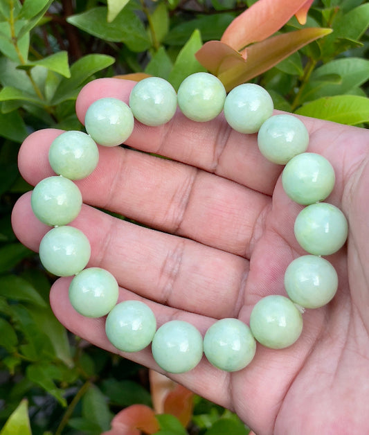 Close-up of a 13.4mm natural Grade A Burmese jadeite beaded bracelet featuring icy apple green, forest green, and milky white beads, item JBB171
