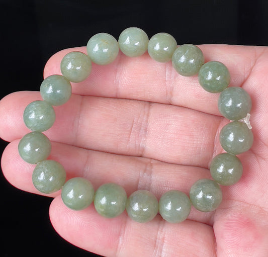 Close-up of a 10.3mm natural Grade A Burmese jadeite beaded bracelet featuring hand-shaped icy apple green beads, item JBB131