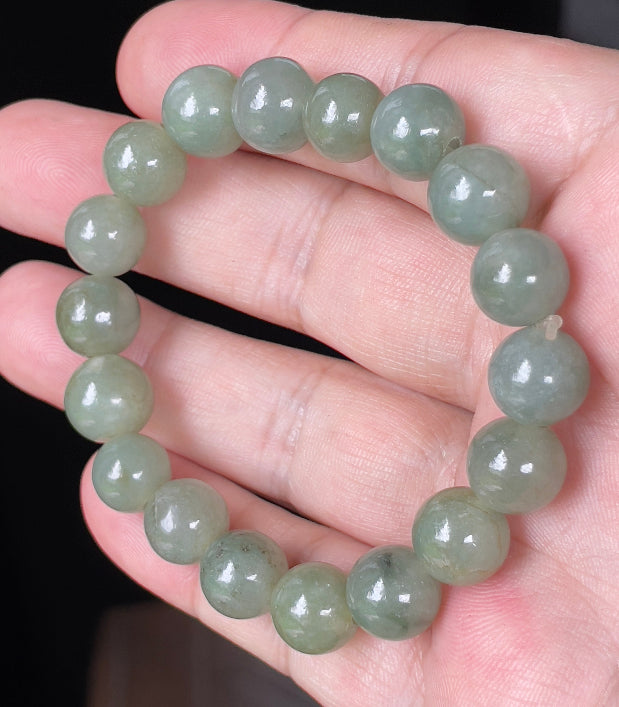 Close-up of a 10.3mm natural Grade A Burmese jadeite beaded bracelet featuring hand-shaped icy apple green beads, item JBB132