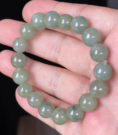 Close-up of a 10.3mm natural Grade A Burmese jadeite beaded bracelet featuring hand-shaped icy apple green beads, item JBB132