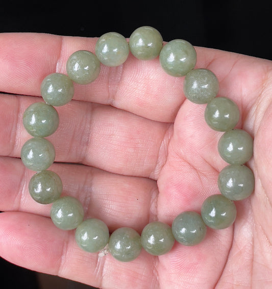 Close-up of a 10mm natural Grade A Burmese jadeite beaded bracelet featuring hand-shaped icy apple green beads, item JBB129