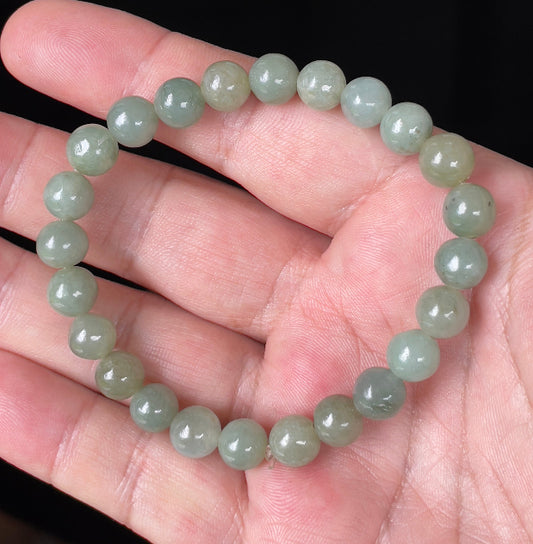 Close-up of an 8.2mm natural Grade A Burmese jadeite beaded bracelet featuring elegant icy apple green hues, item JBB121