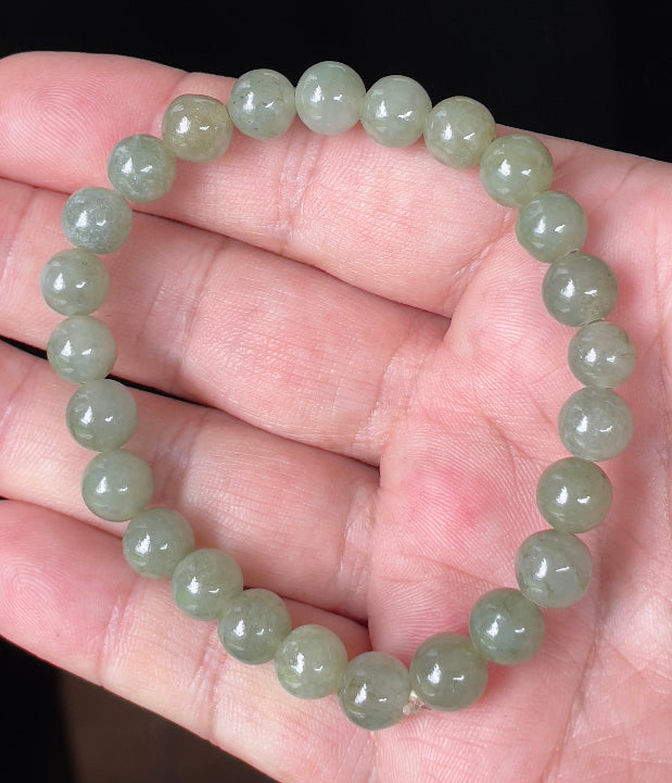 Close-up of an 8.2mm natural Grade A Burmese jadeite beaded bracelet featuring icy apple green hues, item JBB124