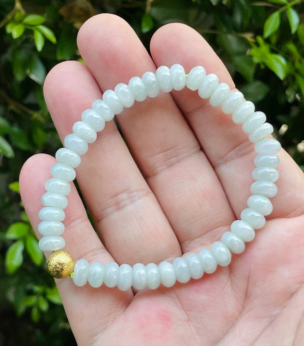 Handcrafted genuine Grade A Burmese jadeite stretch bracelet showcasing beautiful icy apple green beads and a matte-textured golden bead