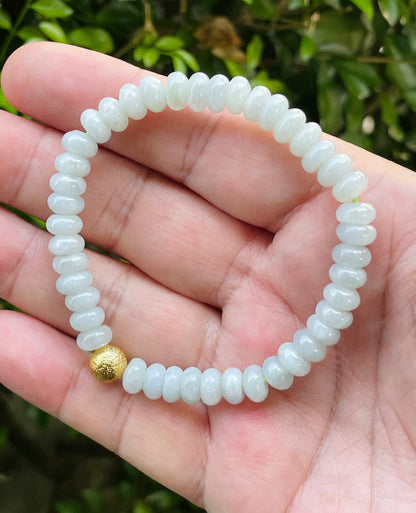 Handcrafted genuine Grade A Burmese jadeite stretch bracelet showcasing beautiful icy apple green beads and a matte-textured golden bead