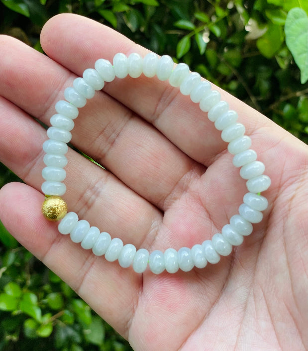 Handcrafted genuine Grade A Burmese jadeite stretch bracelet showcasing beautiful icy apple green beads and a matte-textured golden bead