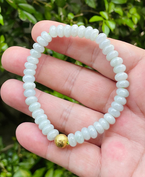 Handcrafted genuine Grade A Burmese jadeite stretch bracelet showcasing beautiful icy apple green beads and a matte-textured golden bead