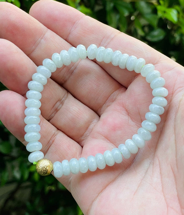 Handcrafted genuine Grade A Burmese jadeite stretch bracelet showcasing beautiful icy apple green rondelle beads and a matte-textured golden bead