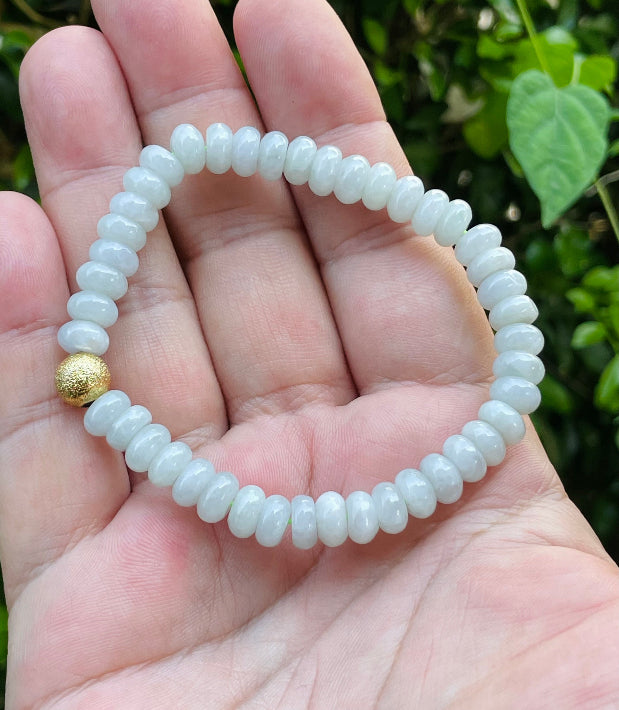 Handcrafted genuine Grade A Burmese jadeite stretch bracelet showcasing beautiful icy apple green rondelle beads and a matte-textured golden bead