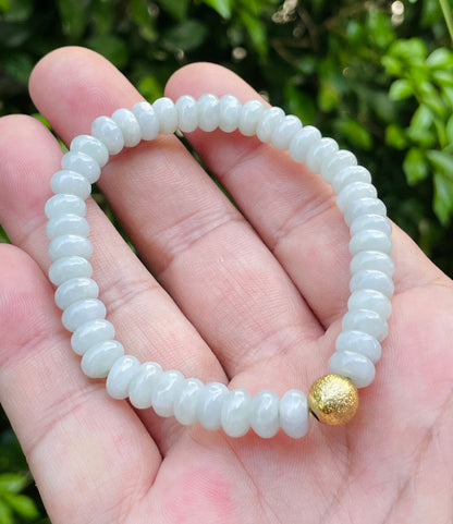 Handcrafted genuine Grade A Burmese jadeite stretch bracelet showcasing beautiful icy apple green rondelle beads and a matte-textured golden bead