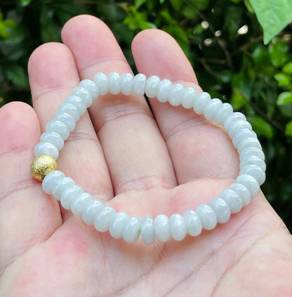 Handcrafted genuine Grade A Burmese jadeite stretch bracelet showcasing beautiful icy apple green rondelle beads and a matte-textured golden bead