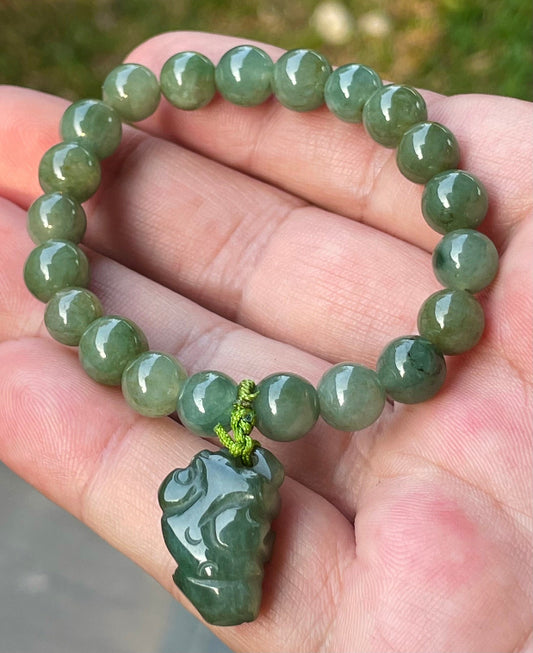 Close-up of an 8.2mm natural Grade A Burmese jadeite beaded bracelet featuring icy deep mossy green beads and a Pixiu pendant, item JBB181