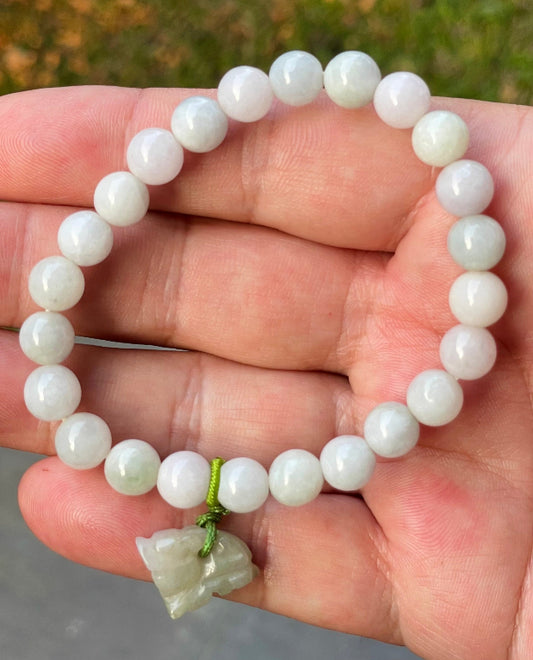 Close-up of an 8mm natural Grade A Burmese jadeite beaded bracelet featuring icy milky white and apple green beads with a tiger pendant, item JBB184