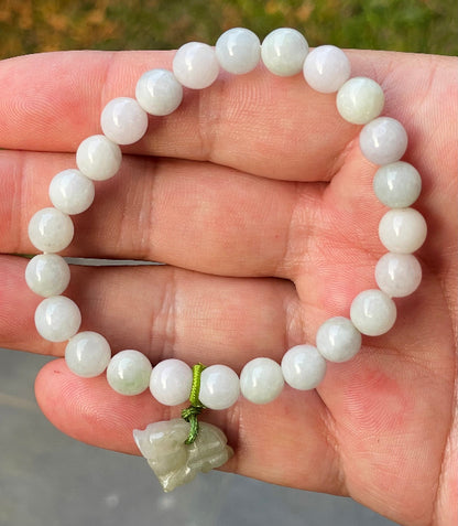 Handcrafted genuine Grade A Burmese jadeite stretch bracelet showcasing beautiful icy milky white and apple green beads with a hand-carved tiger pendant