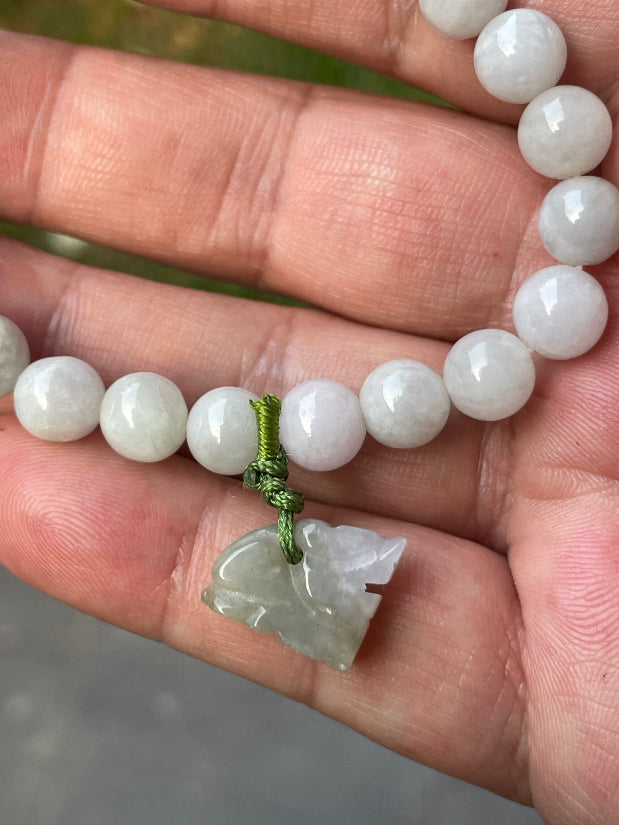 Handcrafted genuine Grade A Burmese jadeite stretch bracelet showcasing beautiful icy milky white and apple green beads with a hand-carved tiger pendant