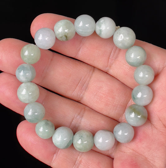 Close-up of a 10.6mm natural Grade A Burmese jadeite beaded bracelet featuring hand-shaped imperial green, apple green, and milky white beads, item JBB143