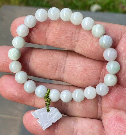Handcrafted genuine Grade A Burmese jadeite stretch bracelet showcasing beautiful milky white and icy apple green beads with a hand-carved tiger pendant