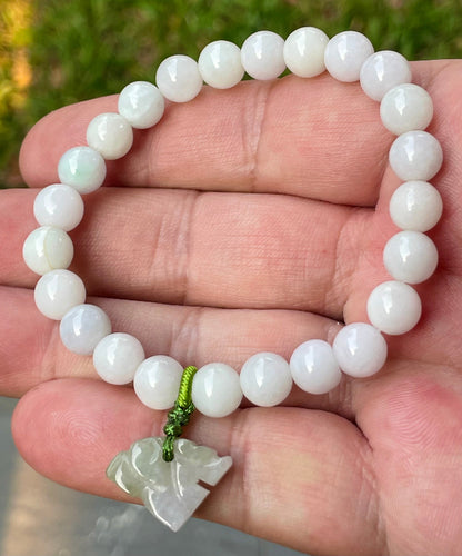 Handcrafted genuine Grade A Burmese jadeite stretch bracelet showcasing beautiful milky white and light lavender beads with a hand-carved tiger pendant