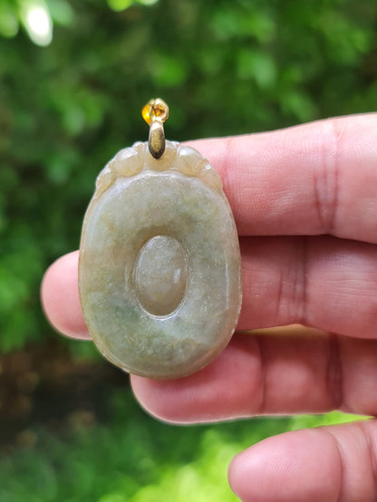 Close-up of a natural Grade A Burmese jadeite pendant in icy imperial green, moss green, and honey hues carved as a Donut Bi Disc, item JOP001