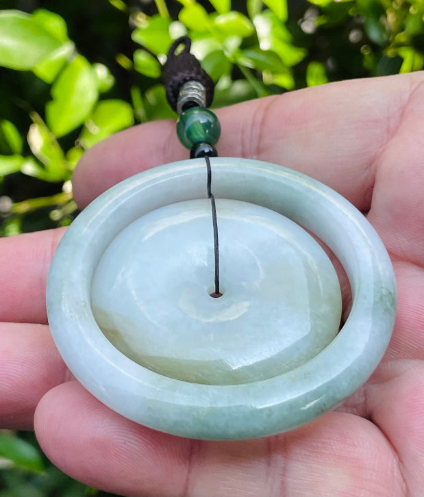 Handcrafted genuine Grade A Burmese jadeite amulet with green and milky white colors representing prosperity and purification