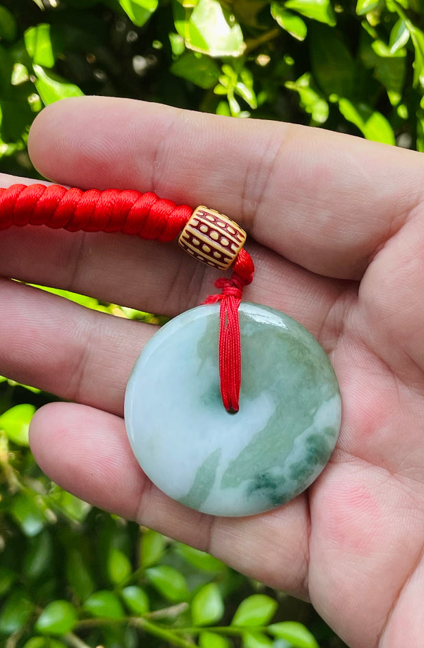 Handcrafted genuine Grade A Burmese jadeite amulet with forest green and white colors representing prosperity and purification