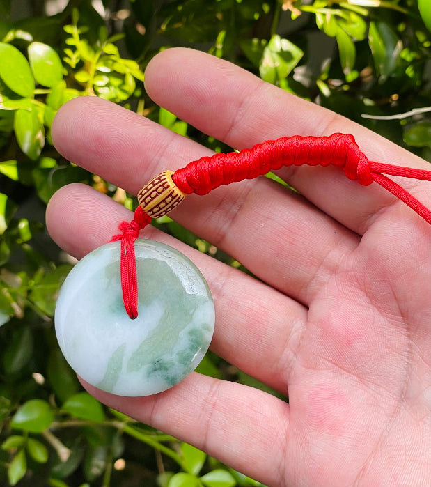 Handcrafted genuine Grade A Burmese jadeite amulet with forest green and white colors representing prosperity and purification