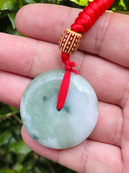 Handcrafted genuine Grade A Burmese jadeite amulet with forest green and white colors representing prosperity and purification