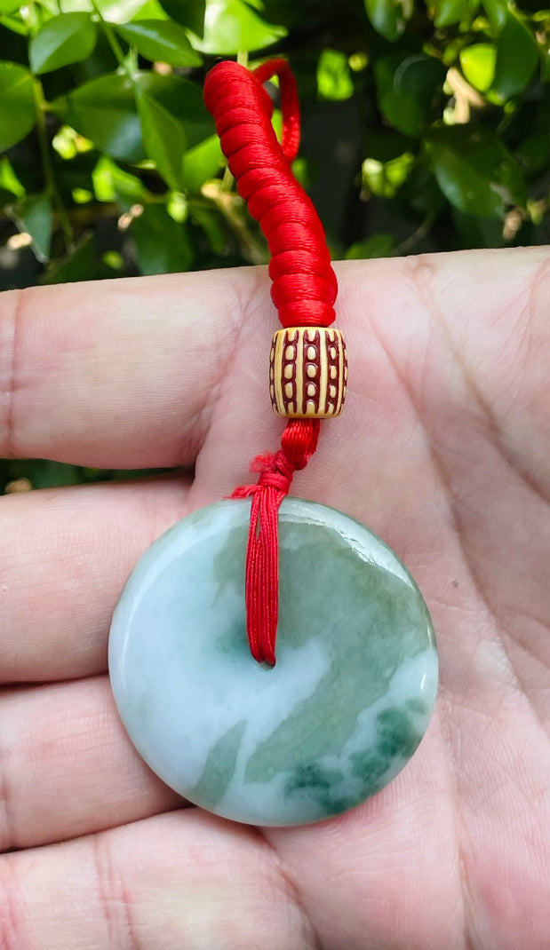 Handcrafted genuine Grade A Burmese jadeite amulet with forest green and white colors representing prosperity and purification