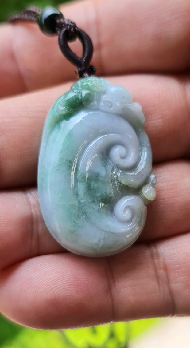 Handcrafted genuine Grade A Burmese jadeite amulet with green and milky white colors representing prosperity and focus