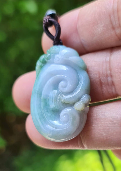 Handcrafted genuine Grade A Burmese jadeite amulet with green and milky white colors representing prosperity and focus