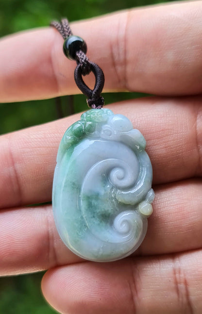 Handcrafted genuine Grade A Burmese jadeite amulet with green and milky white colors representing prosperity and focus