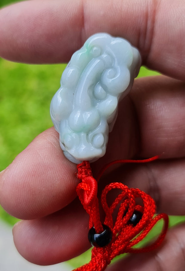 Close-up of a natural Grade A Burmese jadeite pendant featuring icy bluish and imperial green hues hand-carved with a Pixiu motif, item JP100