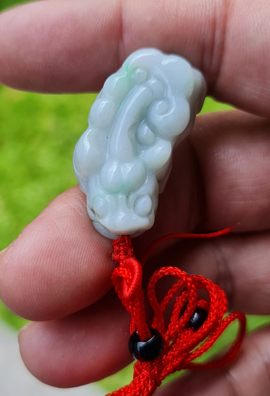 Close-up of a natural Grade A Burmese jadeite pendant featuring icy bluish and imperial green hues hand-carved with a Pixiu motif, item JP100