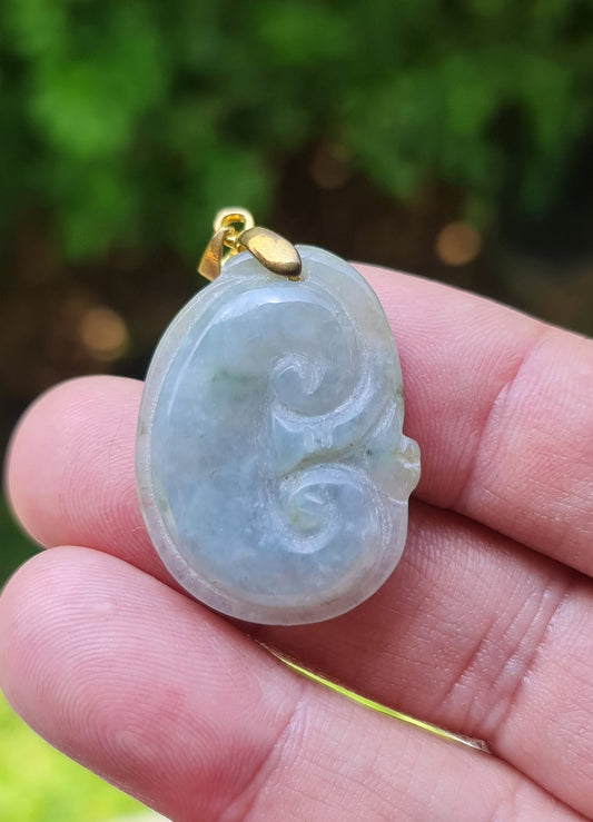 Close-up of a vintage natural Grade A Burmese jadeite pendant in icy bluish moss green and milky white carved as a Ruyi Swirl, item JOP005