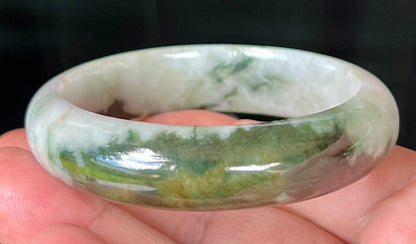 Close-up of deep forest green and milky white marbling on apple green jadeite bangle