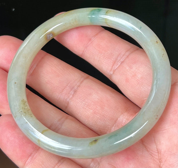 Close-up of honey and imperial green marbling on icy apple green jadeite bangle